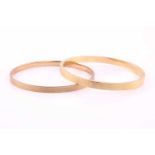 Two gold bangles comprising of a 15ct hollow bangle the interior diameter approximately 6.5cm and