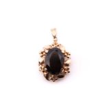 A single stone smokey quartz pendant; the oval cut stone in foliate mount to plain bale, marked '