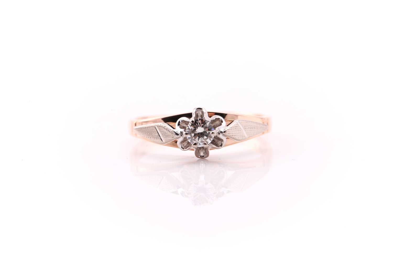 A single stone diamond ring; the round brilliant cut diamond in raised, scalloped, bi-coloured 14