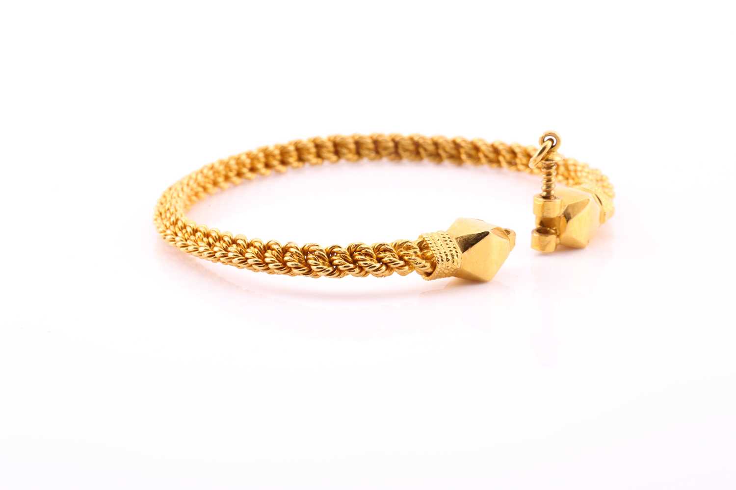 A yellow metal torque style bangle, the rope twist bangle with faceted terminals and screw-down - Image 2 of 3