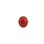 Red coral ring, modern, the oval coral cabochon rubover set to a yellow mount and simple shank