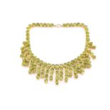 A peridot fringe necklace, oval and round cuts claw set to gilt metal mount, peridots averaging 8.