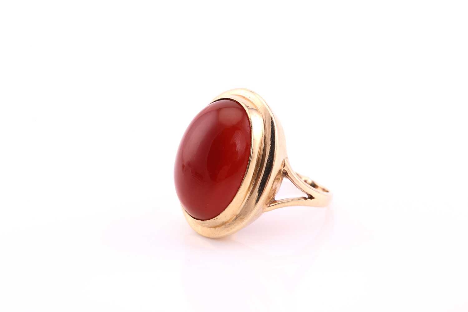 A carnelian cabochon ring, mid 20th century, the 19 x 14.5mm oval cabochon collet set to a yellow - Image 2 of 4