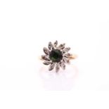 A tourmaline and diamond cluster ring, the round cut tourmaline claw set in white within a leaf