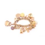 A yellow gold charm bracelet, consisting of various charms individually hallmarked as 9ct or 18ct,