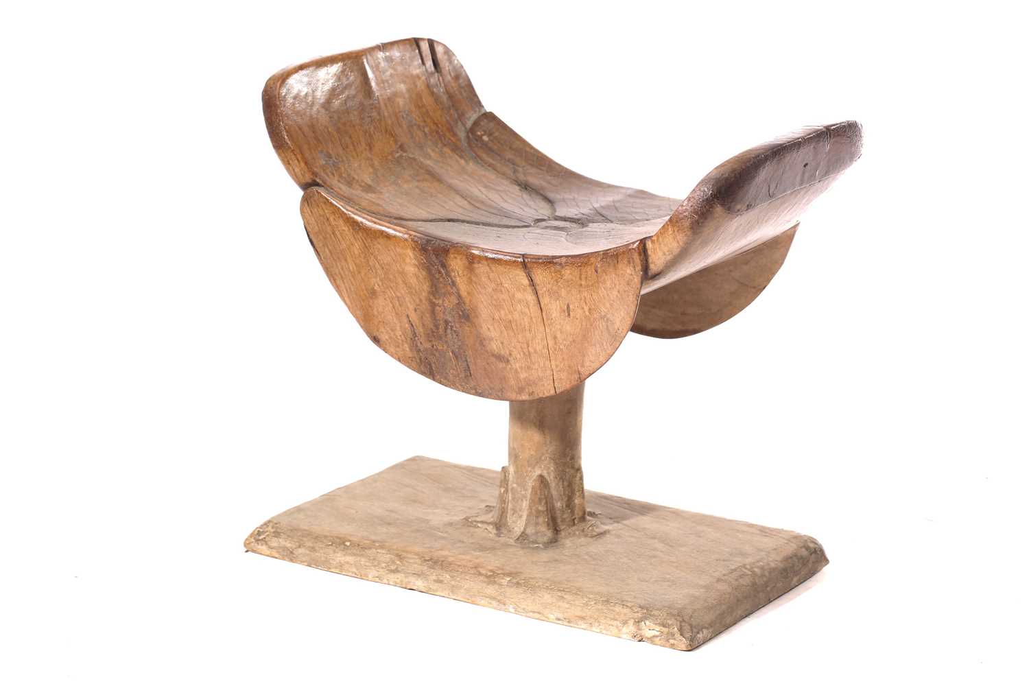 An Ashanti stool, Ghana, the dished top of carved petal form on a circular column with carved