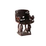 A Fon hardwood throne chair, Benin, the backrest carved with a lion to the upper corners, and