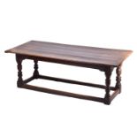 A 17th century oak refectory table with clamped plank top on a box frame base with slender cup and