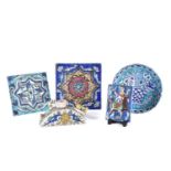 A group of five Iznik-style items consists of three tiles, the largest 25cm square, the smallest
