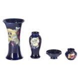 Four items of Moorcroft, comprising a large pansy vase, another smaller pansy vase, a small pedestal