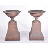 A pair of decorative cast iron circular tazza with egg and tongue rims and square bases, on separate