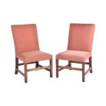 A pair of George III mahogany library chairs with stuff over square backs and seats, on squared