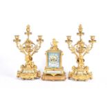 A matched gilt metal clock garniture, 19th century, each with Paris porcelain panels, the clock with