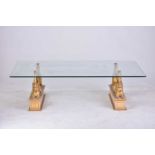 An 'Egyptian Retour' glass-topped rectangular coffee table, 20th century, on gilt composition sphinx