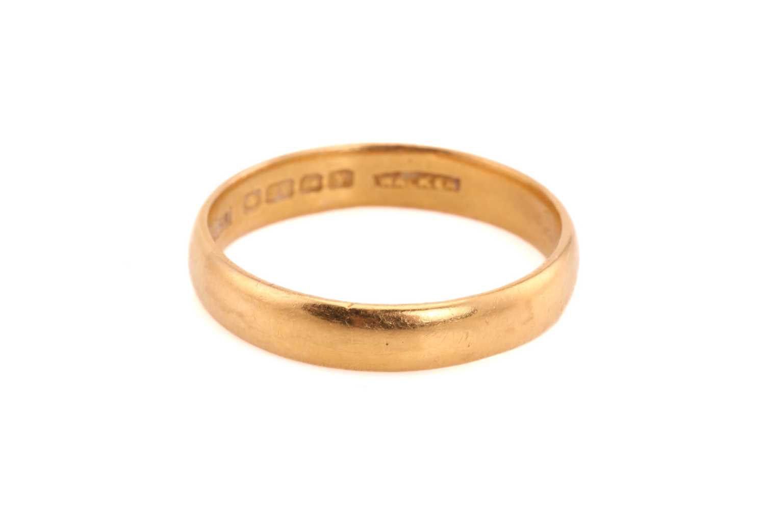 A 22ct yellow gold wedding band, comprises a plain D-section ring with Birmingham hallmarks and