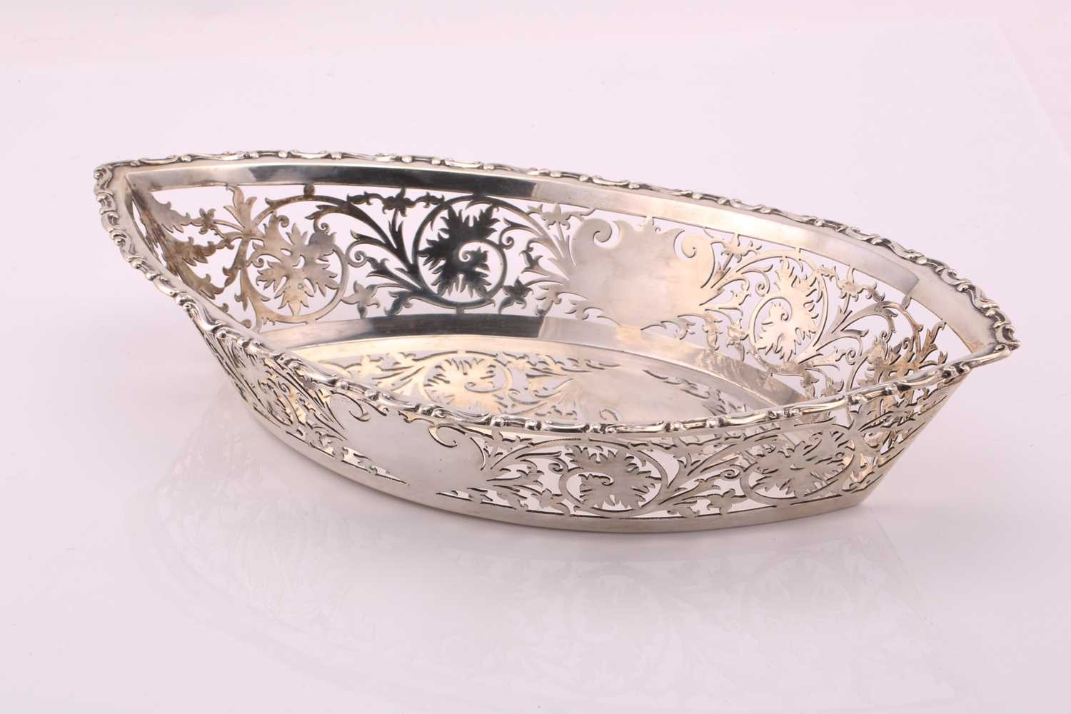 An Edwardian navette form pierced silver breadbasket. Chester 1902 by William Neale. With cast and - Image 3 of 4