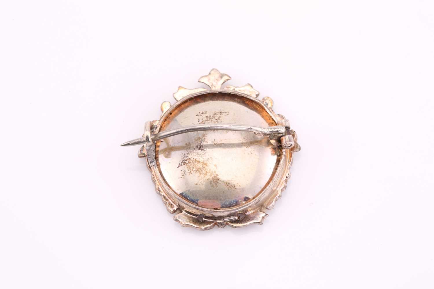 An Edwardian brooch, containing a glazed miniature of a lady, framed with a floral ornated white - Image 2 of 2