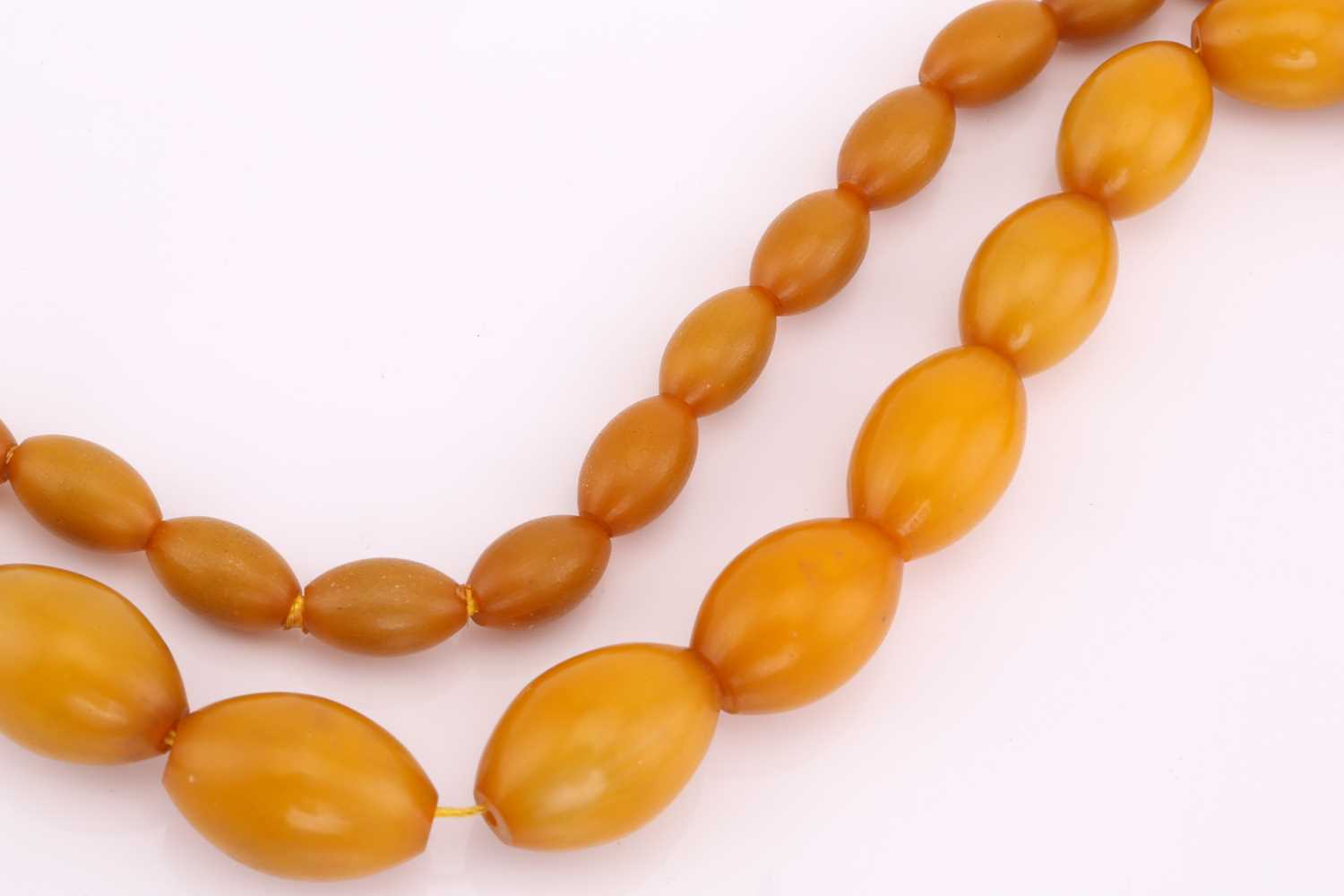 A butterscotch coloured amber bead necklace, strung with barrel-shaped opaque beads, approximately - Image 2 of 2