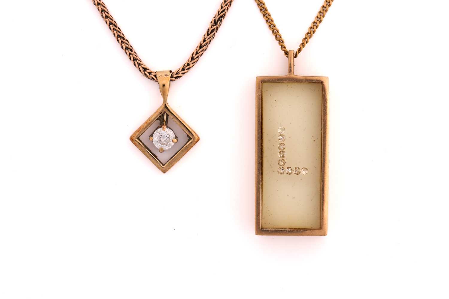 Two pendant necklaces, one consisting of 'floating' gemstones in a transparent rectangular prism