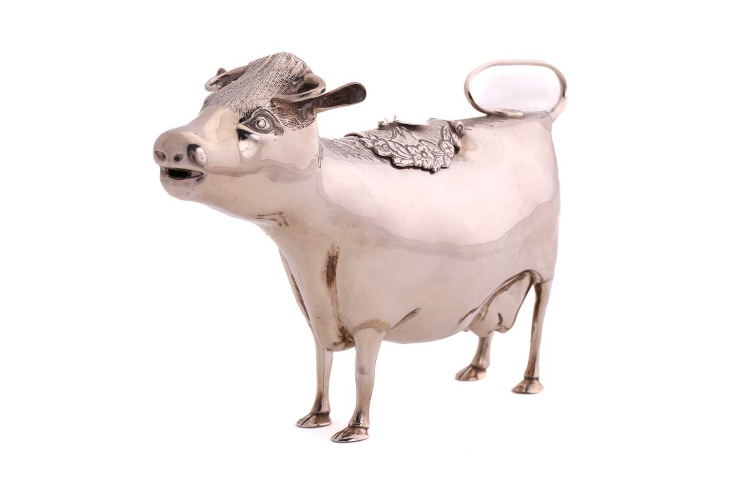 A 20th century silver cow creamer; of traditional form, the hinged cover with an applied bee. London