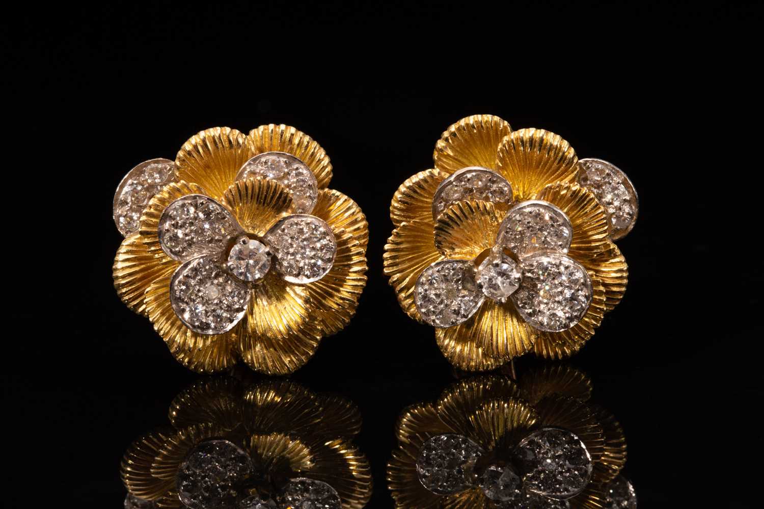 A pair of Kutchinsky platinum and 18ct yellow gold diamond earrings, each comprises a flower head