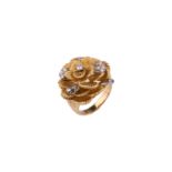 A Kutchinsky platinum and 18ct yellow gold diamond ring, comprises a flower head with layering