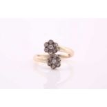 A bypass diamond ring with double daisy heads, consists of diamond clusters estimating a total