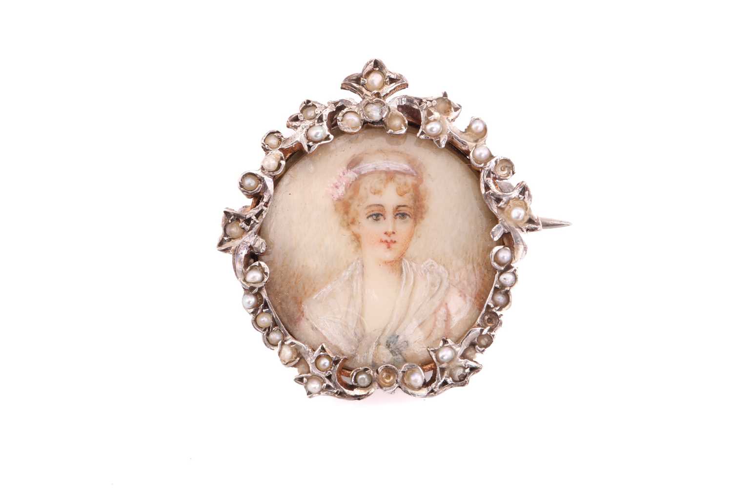 An Edwardian brooch, containing a glazed miniature of a lady, framed with a floral ornated white