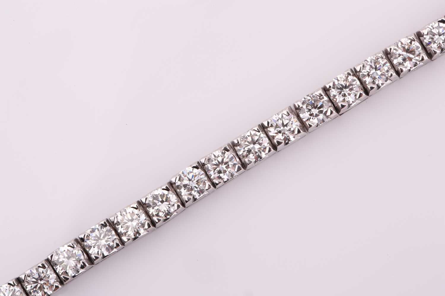 A diamond tennis bracelet, set with thirty-three round brilliant diamonds, each weighing an - Image 5 of 10