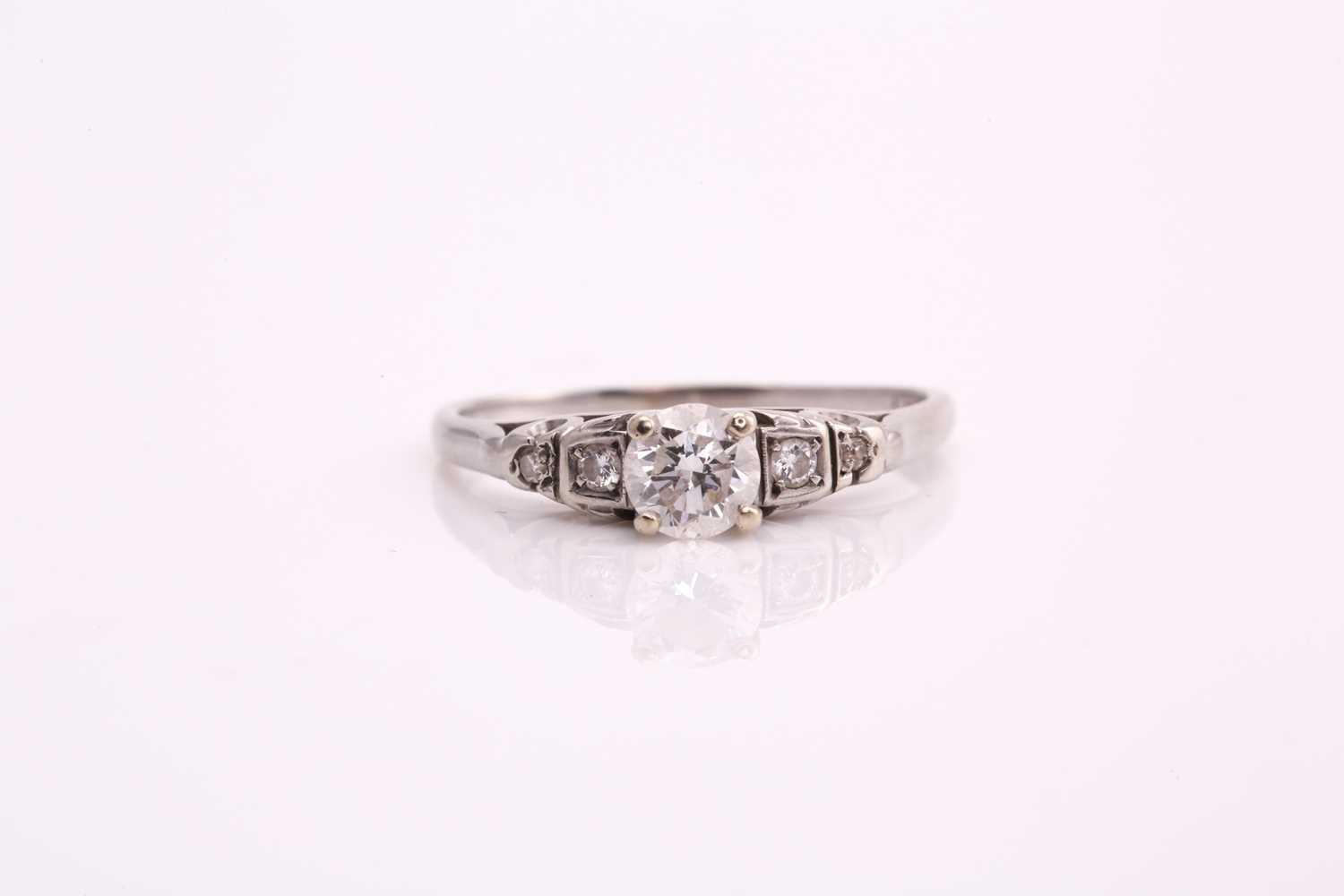 A diamond cathedral engagement ring, consisting of a round brilliant central diamond of 0.37cts,