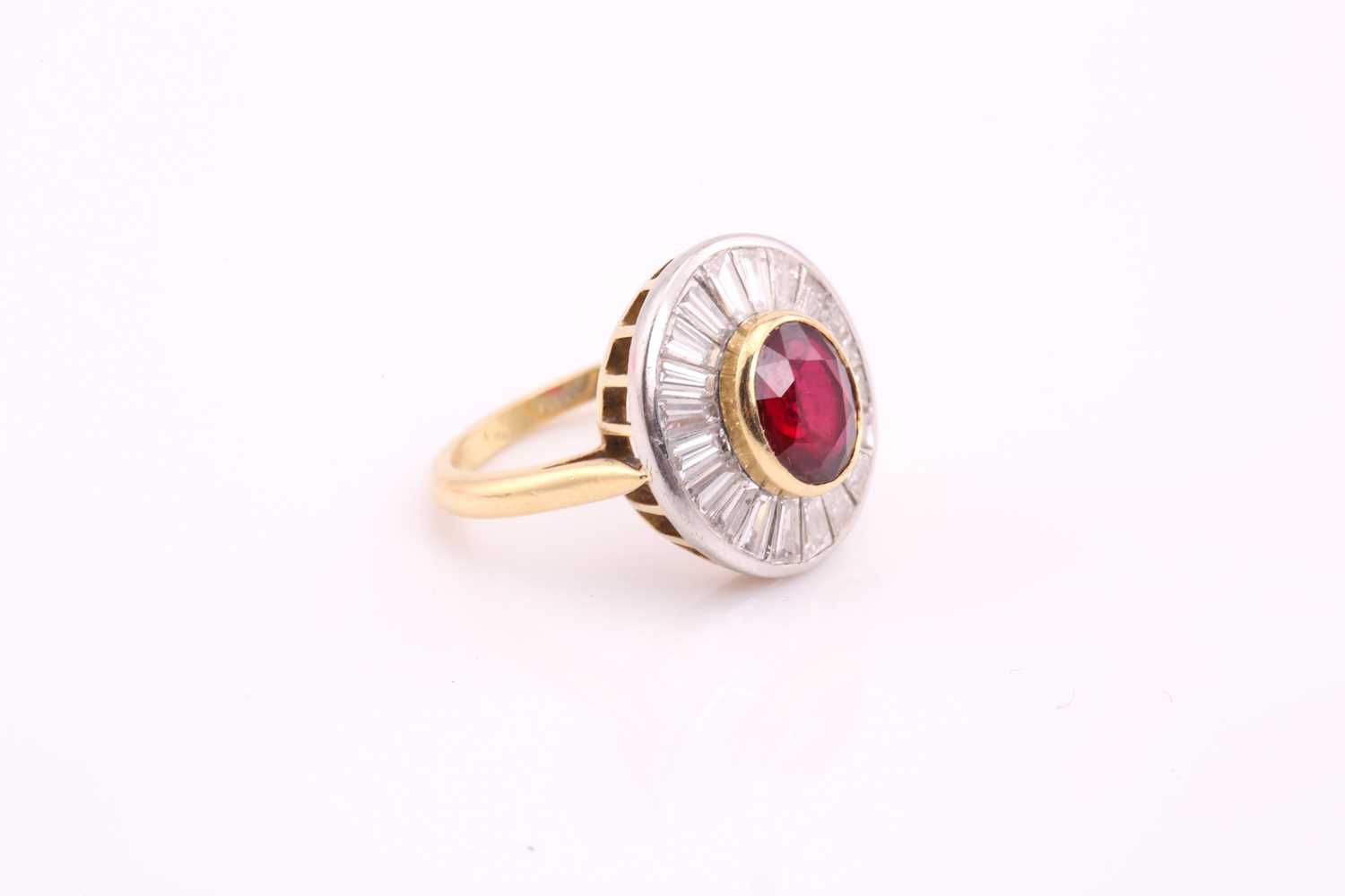 A ruby and diamond cluster ring; the central oval cut ruby in rub over mount within a surround of - Image 3 of 7