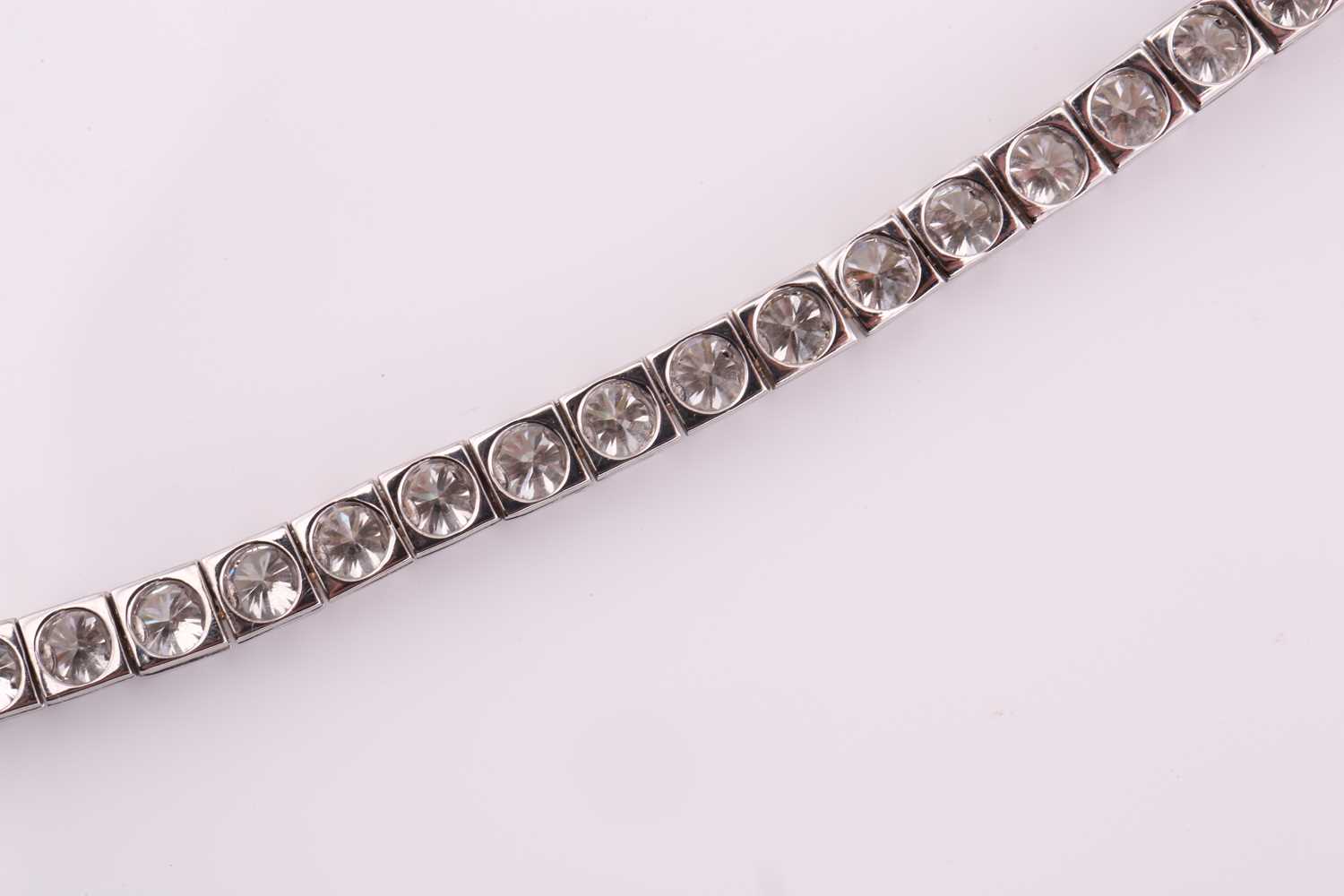 A diamond tennis bracelet, set with thirty-three round brilliant diamonds, each weighing an - Image 6 of 10