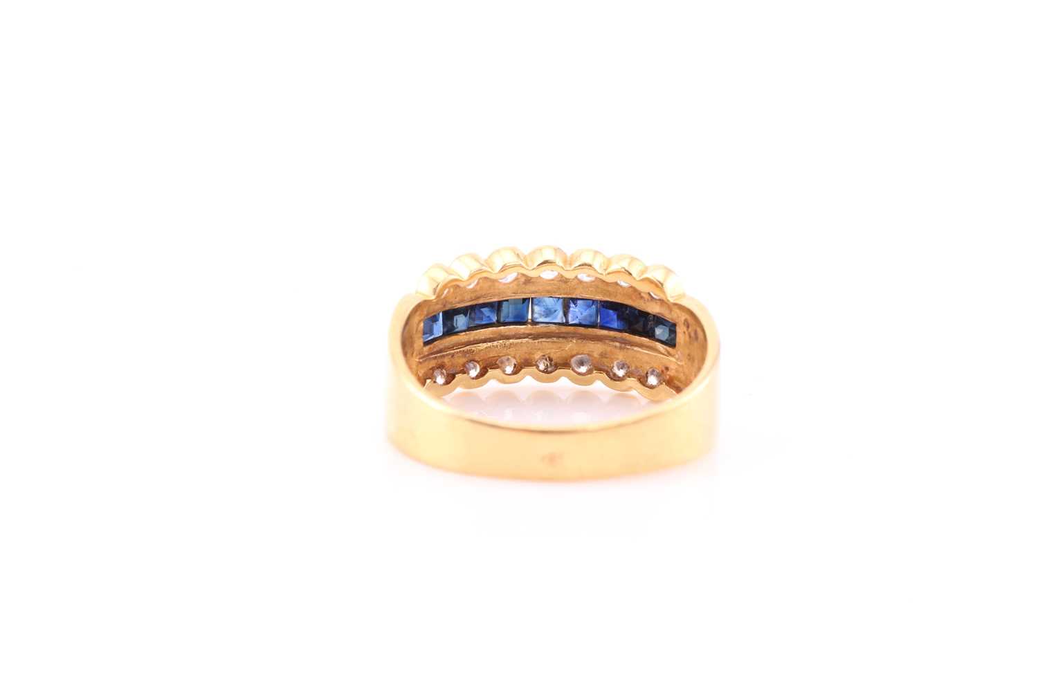 A yellow metal, diamond, and sapphire ring, channel-set to centre with a row of calibre-cut - Image 4 of 4