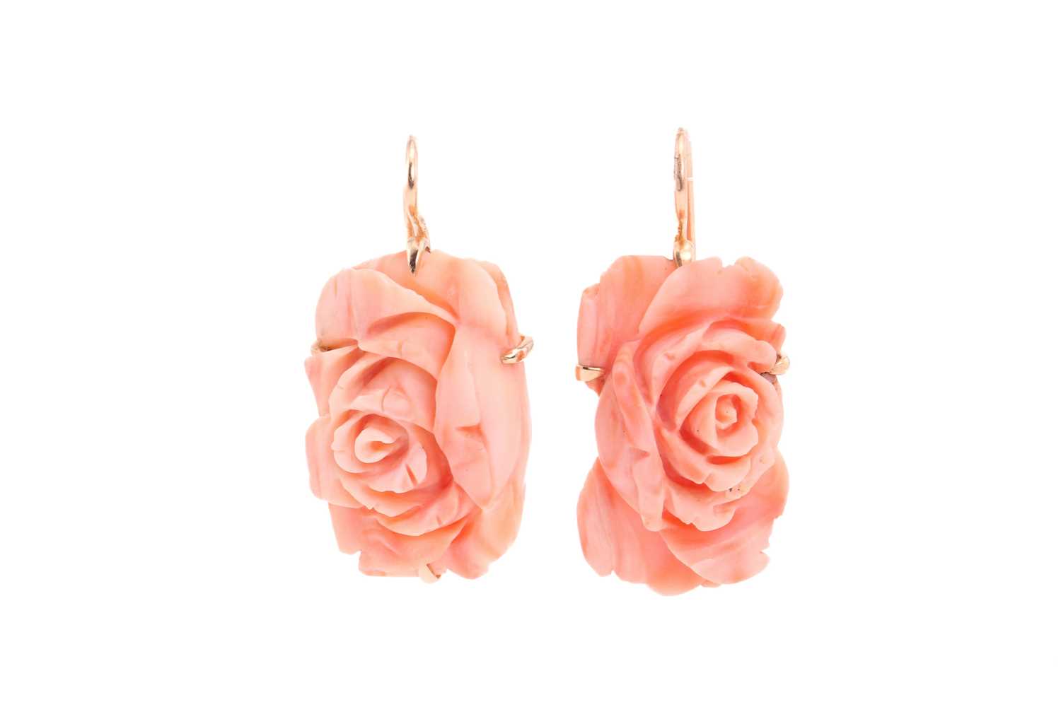 A pair of coral pendant earrings; the carved coral roses in yellow metal cruciform frame mounts to