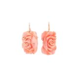 A pair of coral pendant earrings; the carved coral roses in yellow metal cruciform frame mounts to