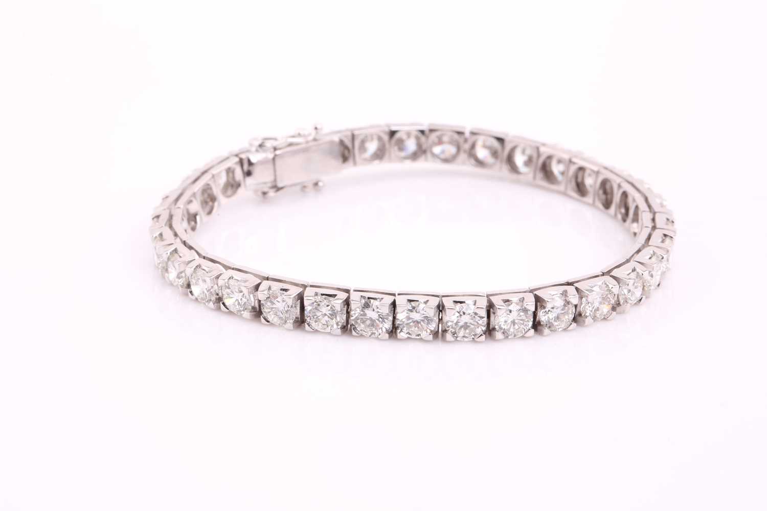 A diamond tennis bracelet, set with thirty-three round brilliant diamonds, each weighing an - Image 2 of 10