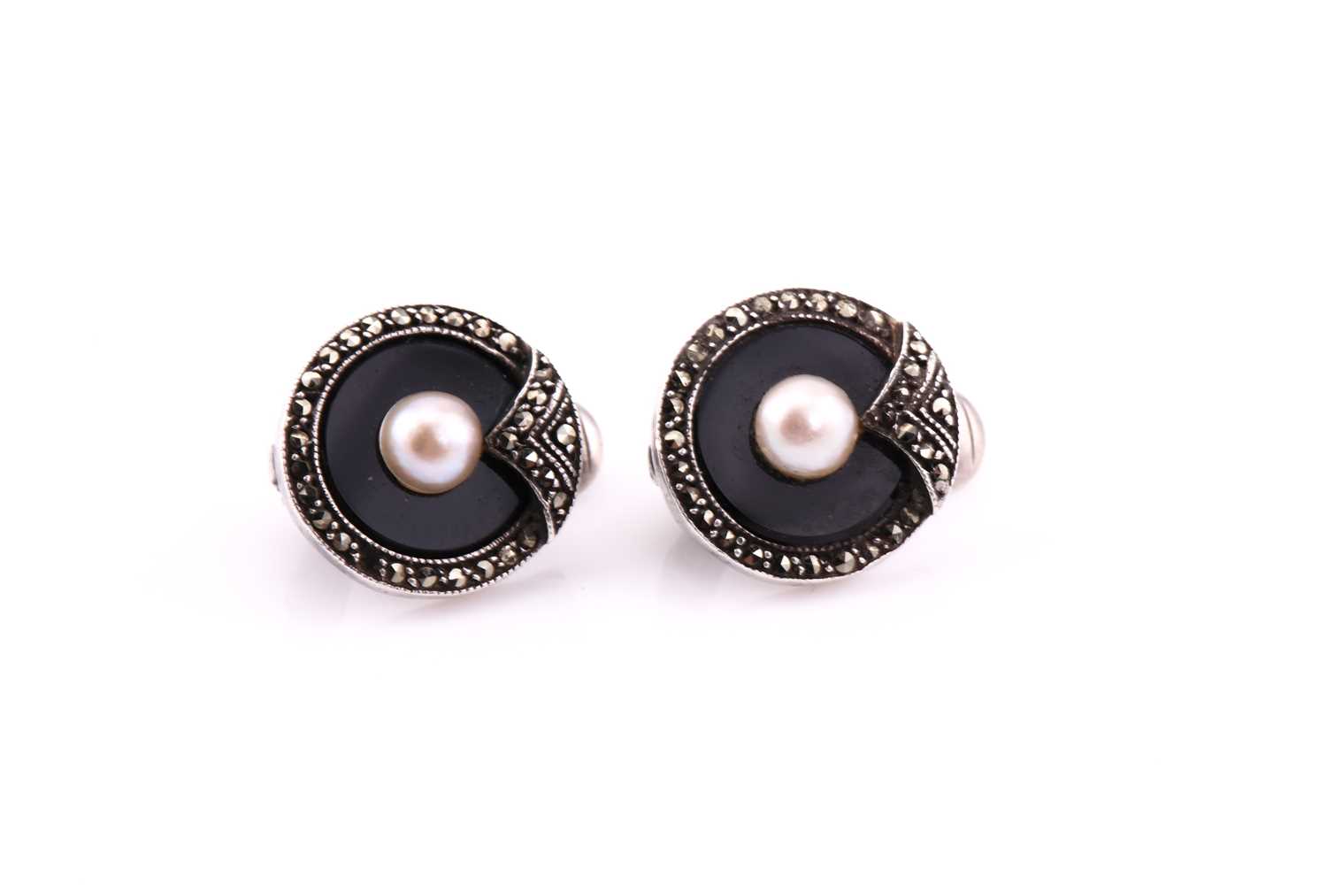 A pair of silver art deco ear clips, consisting of seed pearl highlight on an onyx panel, edged with