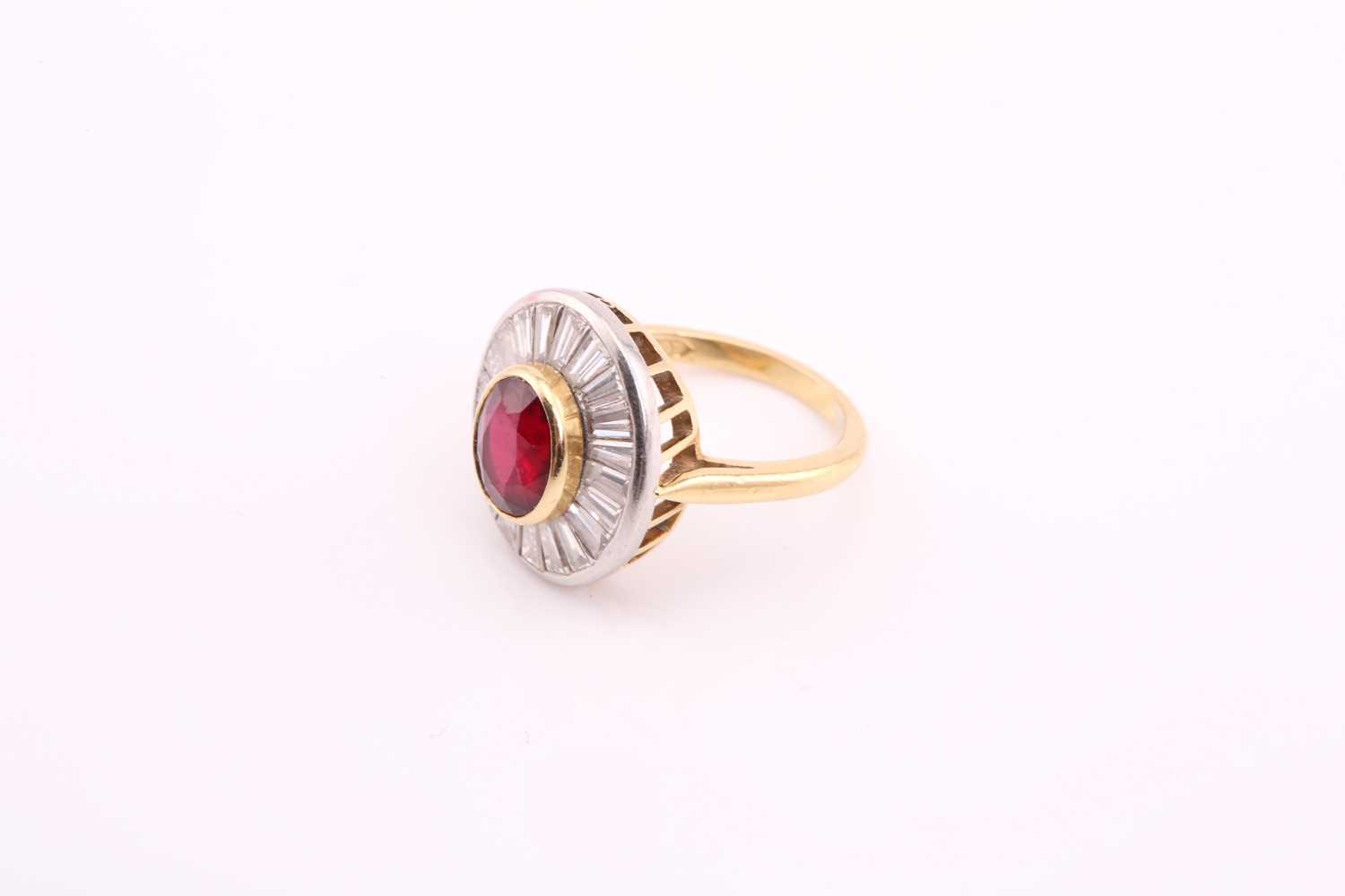 A ruby and diamond cluster ring; the central oval cut ruby in rub over mount within a surround of - Image 4 of 7