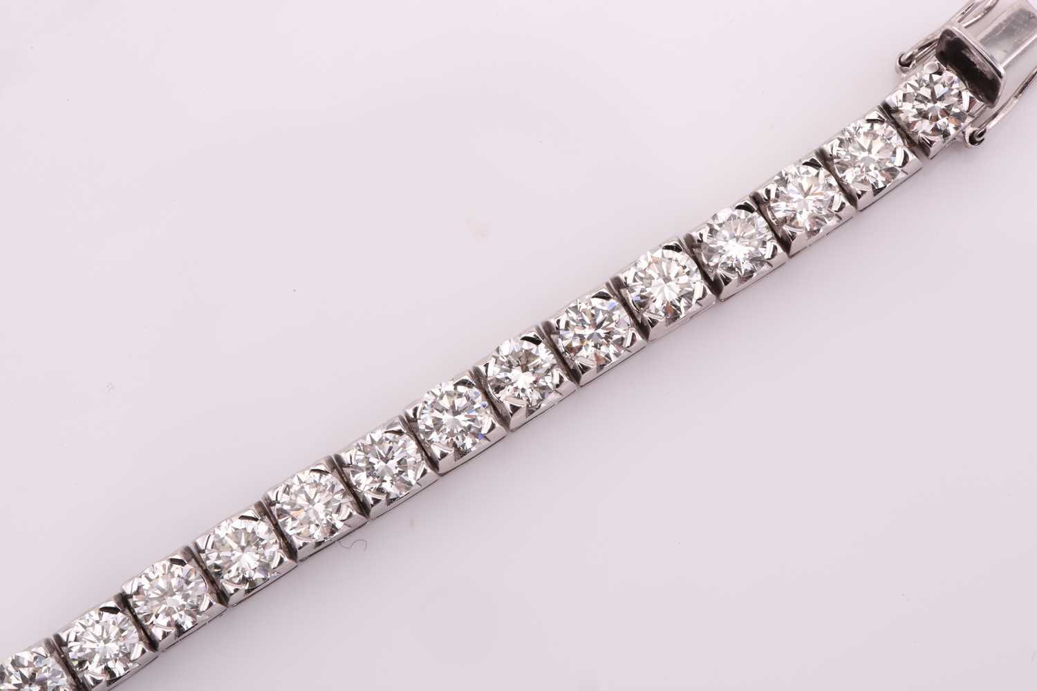 A diamond tennis bracelet, set with thirty-three round brilliant diamonds, each weighing an - Image 9 of 10