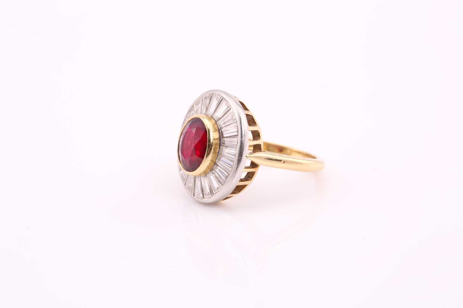A ruby and diamond cluster ring; the central oval cut ruby in rub over mount within a surround of - Image 6 of 7