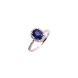 A sapphire entourage ring, consisting of an oval brilliant-cut sapphire with vivid and intense