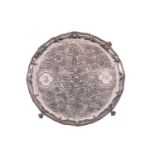 A George III silver salver; shaped circular with raised beaded border above a wreath chased band.