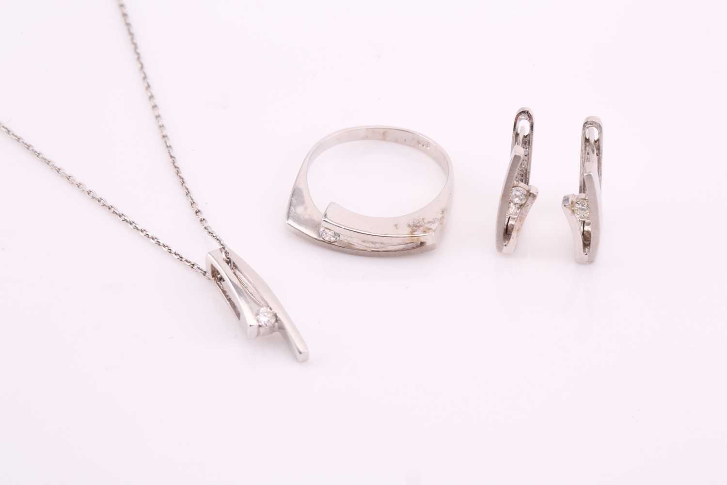 A suite of 14ct white gold and diamond necklace, earrings and ring. The necklace comprises a 0.