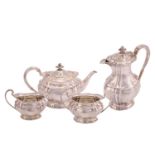 A late Victorian silver four piece tea set; of panelled oval form with reeded loop handles and