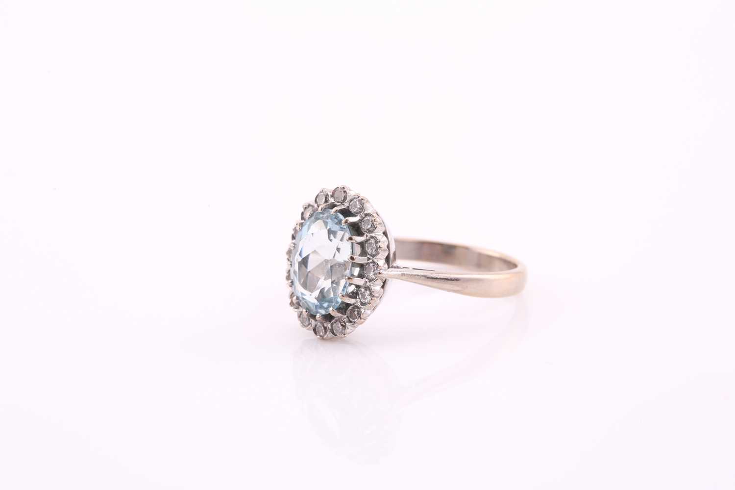 An aquamarine and diamond cluster ring, the oval mixed cut aquamarine 10.2mm x 8mm, surrounded by - Image 3 of 4