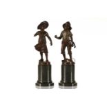 After Wilhelm Schaffert (19th/20th century), a pair of patinated bronze figures, a young boy and