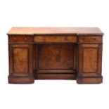 A Victorian walnut and ebonized kneehole writing desk of inverted breakfront form, with a figured