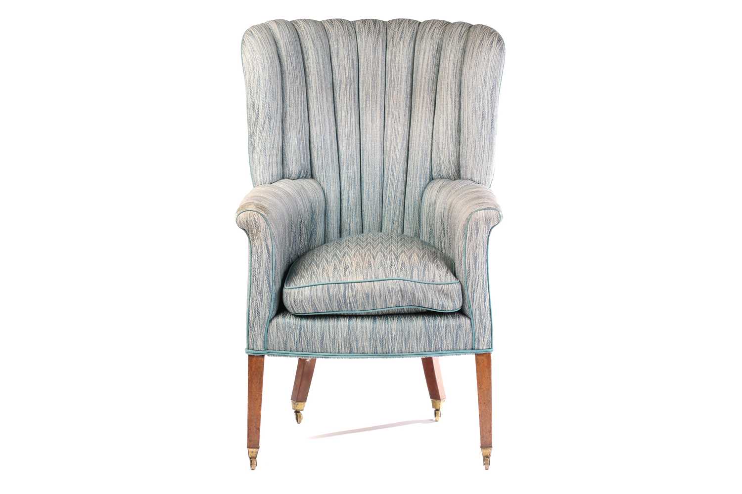 A George III mahogany barrel back fireside armchair, with segmented stuff over upholstered back