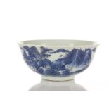 A Chinese blue & white bowl, painted with a fisherman in a boat before a mountainous landscape,