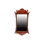A George III mahogany scroll framed wall mirror with carved gilt slip. 90 cm high x 49 cm wide.Old